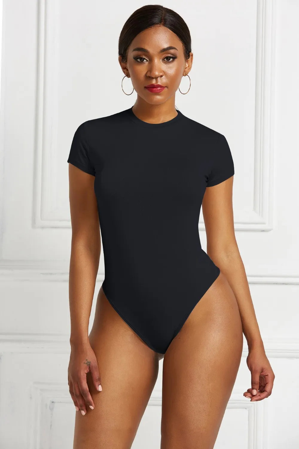 Round neck short sleeve bodysuit in smooth stretchy fabric, fitted silhouette perfect for layering or styling with denim