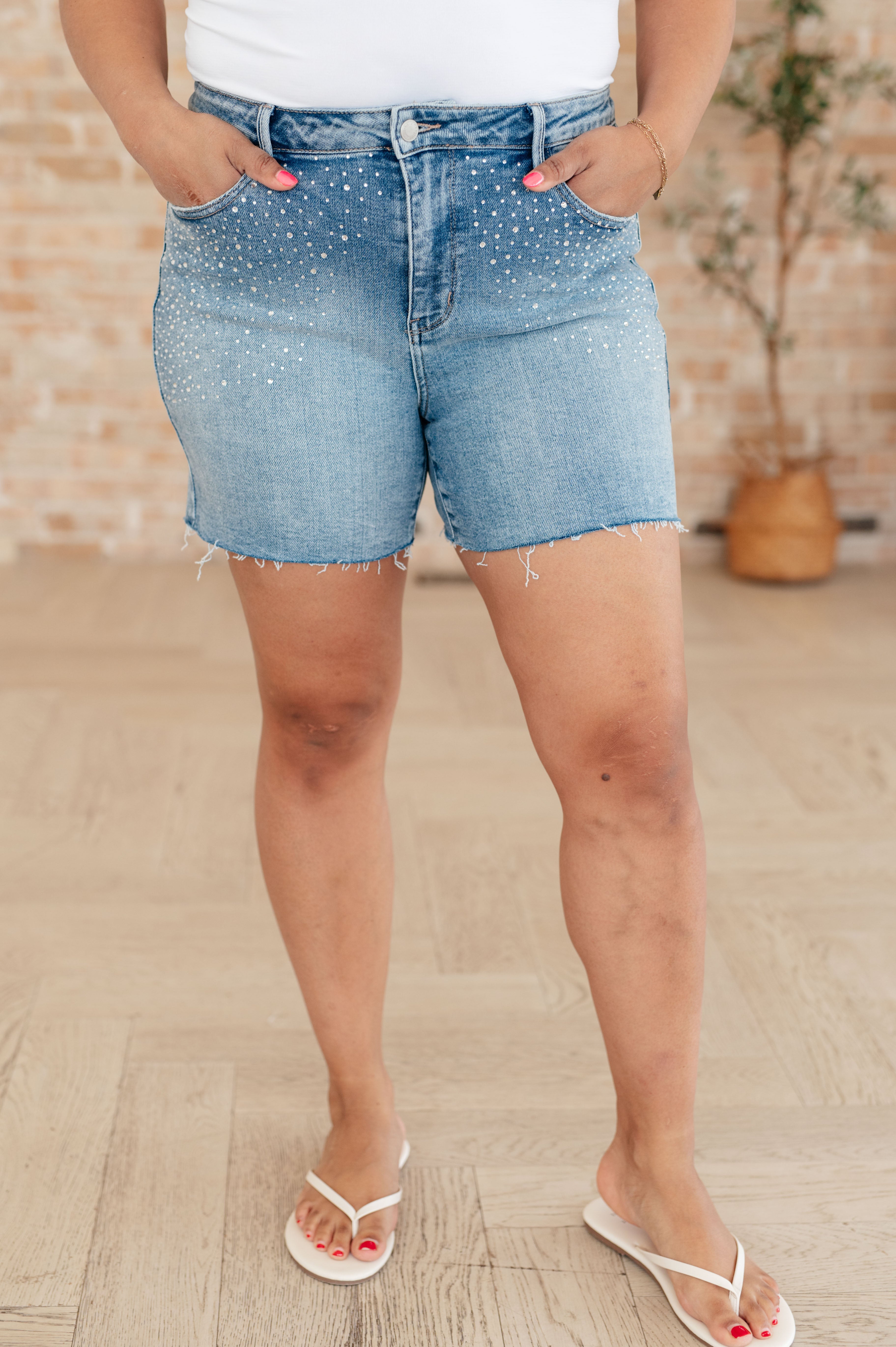 Judy Blue high rise rhinestone cutoff shorts with raw hem and medium wash stretchy denim fit.