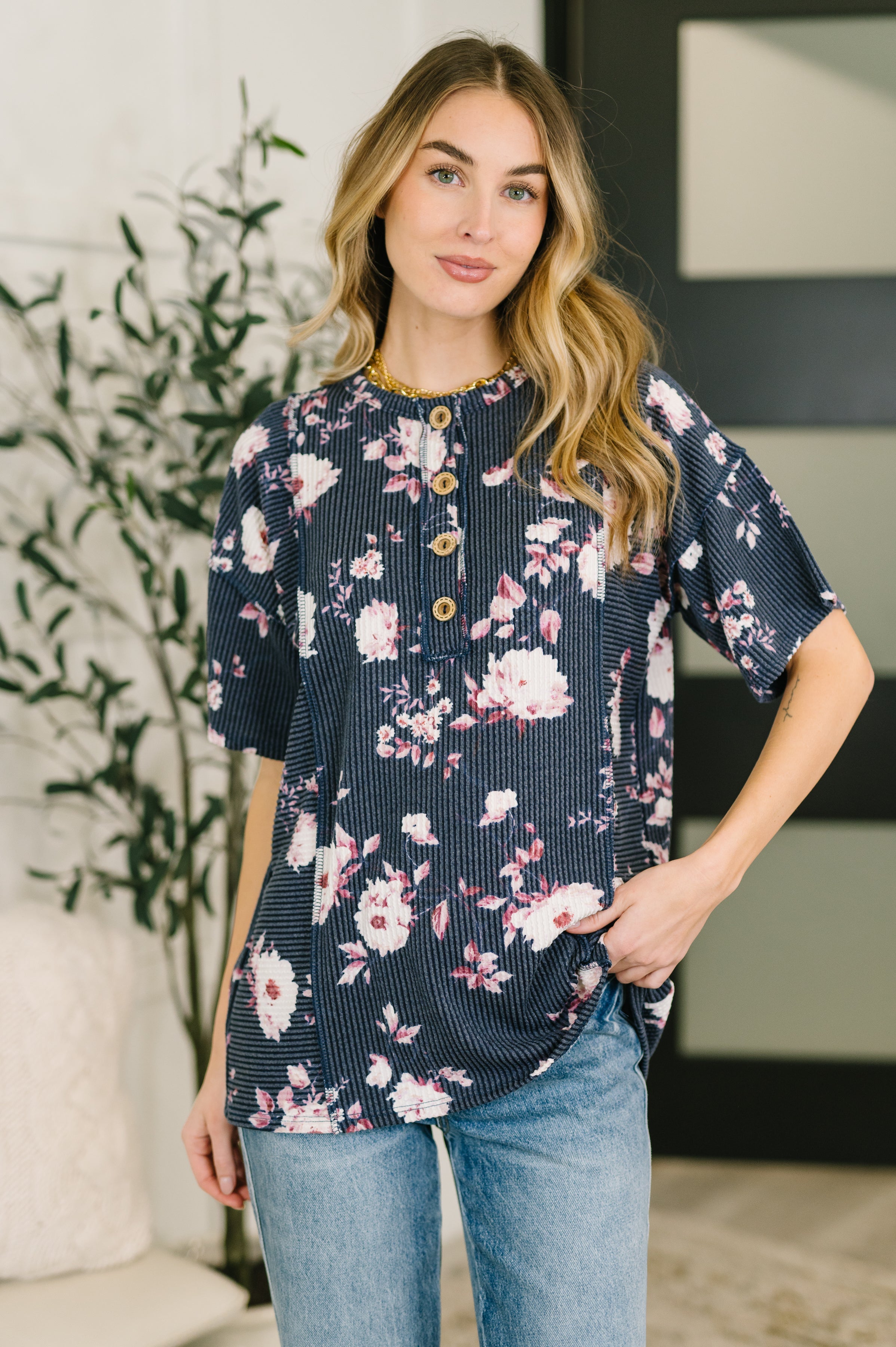 Floral ribbed henley short sleeve top with button neckline and relaxed stretchy fit with arm coverage.