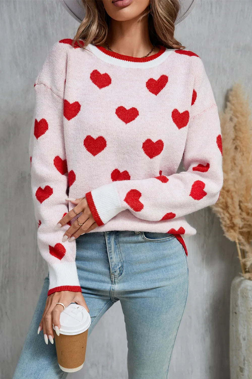 White long sleeve pullover sweater with red heart print. Soft knit, classic round neckline, casual comfy fit for Valentine’s Day and everyday wear.