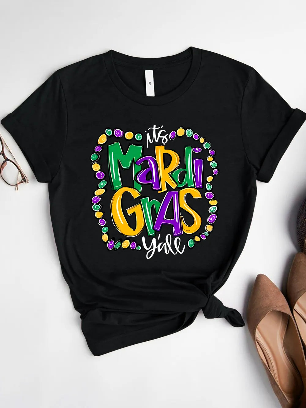 Black graphic tee with festive “Mardi Gras Y’all” design. Soft stretch fit, easy everyday parade-season styling.