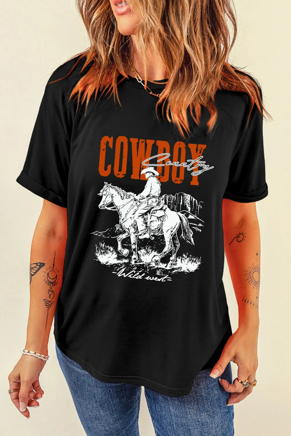 Black graphic tee with bold red “COWBOY” text and cowboy riding a horse. Rugged, western, modern casual style with statement Americana energy.