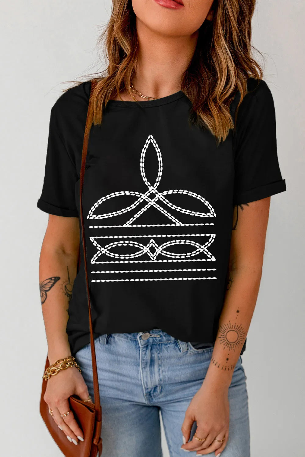 Women’s black western graphic tee with white boot-stitch embroidery pattern, soft casual shirt for cowgirl, denim, and everyday outfits.