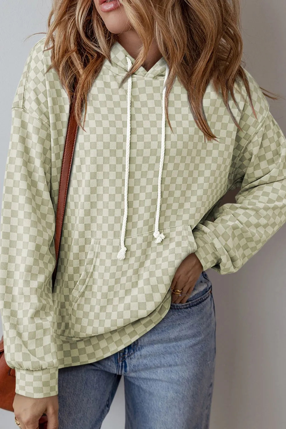 Gum leaf green hoodie with ivory checkered print, kangaroo pocket, and drawstrings. Soft, opaque sweatshirt feel for cozy casual outfits.