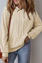 Khaki hoodie with ivory checkered print, kangaroo pocket, and drawstrings. Opaque, soft sweatshirt feel for relaxed everyday outfits.