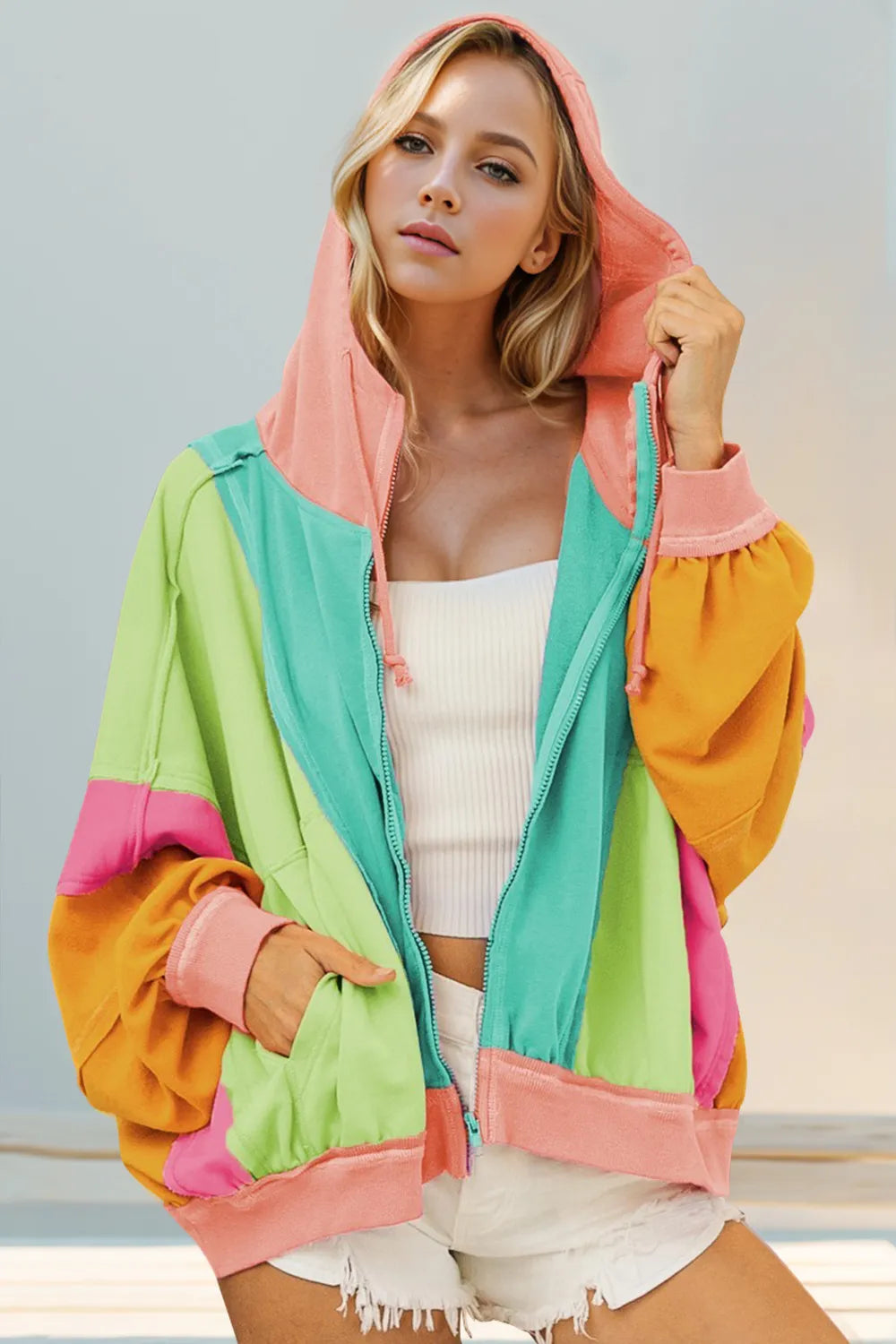 Teal sherbet hoodie with lime, mint, pink, and orange color block panels. Zip up, drawstring hood, exposed seams, and pockets for fun layering.