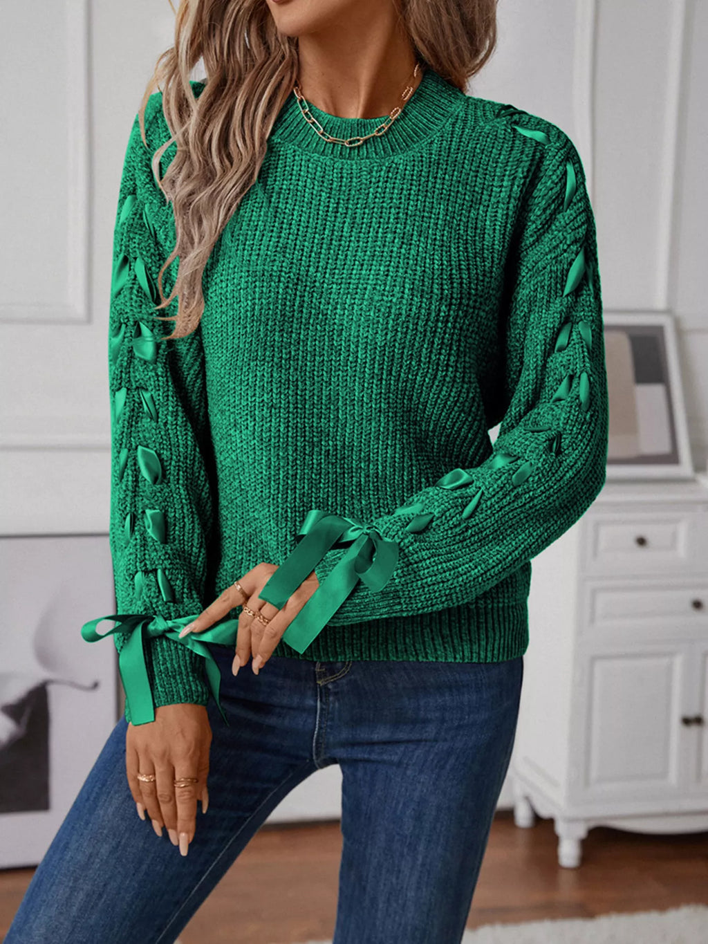 Dark green long sleeve knit sweater with ribbon detail woven down both sleeves. Soft, opaque pullover with a classic round neckline.