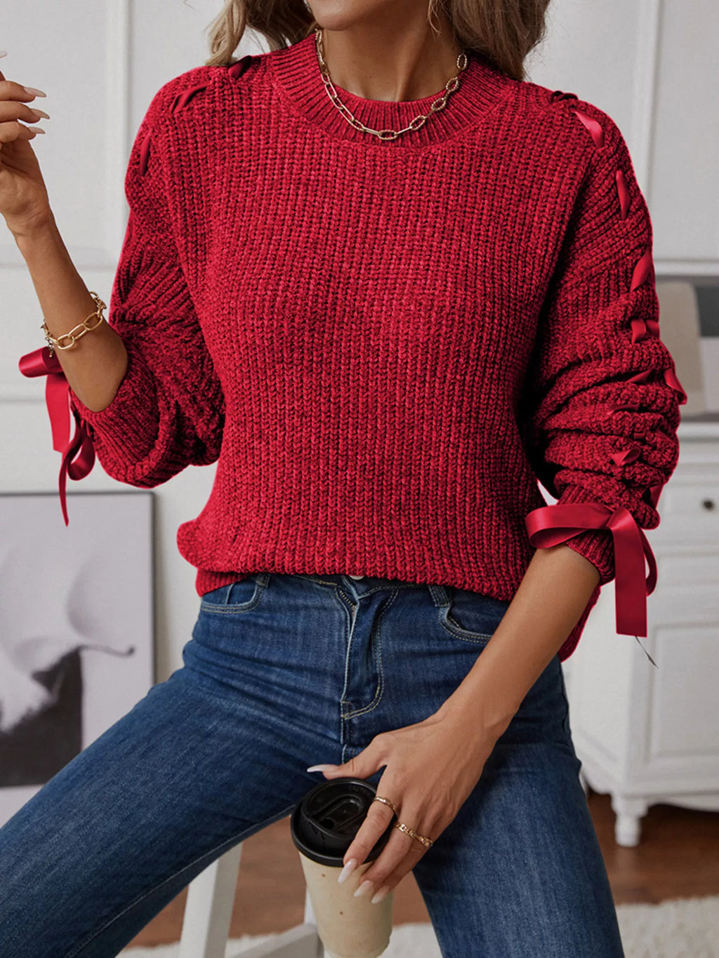 Deep red long sleeve knit sweater with ribbon detail woven down both sleeves. Soft, opaque pullover with a classic round neckline.