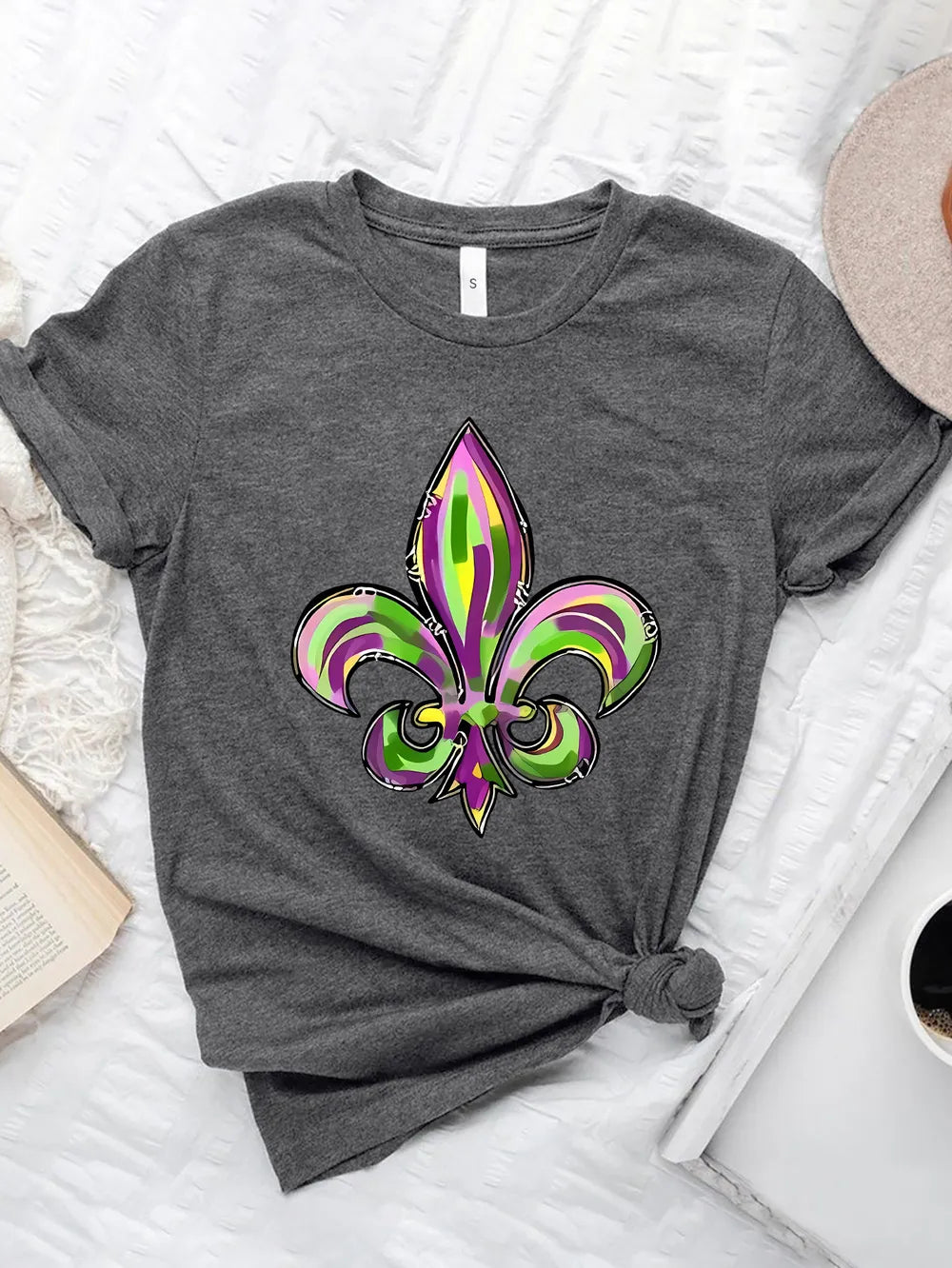 Gray graphic tee with purple, green & gold fleur-de-lis Mardi Gras design. Soft stretch fit for parade season and everyday festive styling.