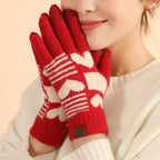Red knitted touchscreen gloves with off-white heart pattern. Warm, soft, stretchy knit with phone-friendly fingertips for winter comfort.