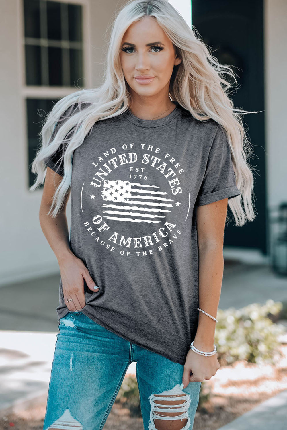 Gray patriotic graphic tee with white “Land of the Free Because of the Brave” 1776 print. A bold, comfy staple for casual everyday style.
