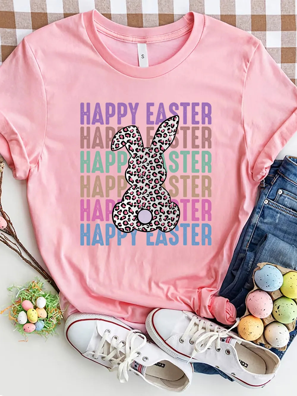 Happy Easter graphic tee with leopard bunny and pastel lettering printed on a pink shirt from Soaring Eagle Boutique.