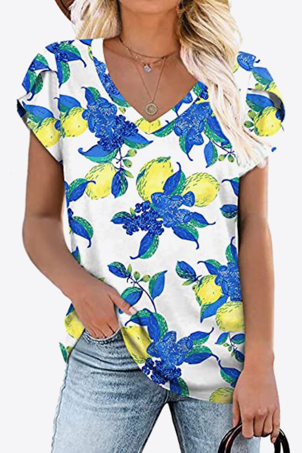 White V-neck blouse with bold azure blue floral print. Petal sleeves, soft stretch knit, casual everyday boutique top.