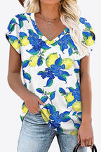 White V-neck blouse with bold azure blue floral print. Petal sleeves, soft stretch knit, casual everyday boutique top.