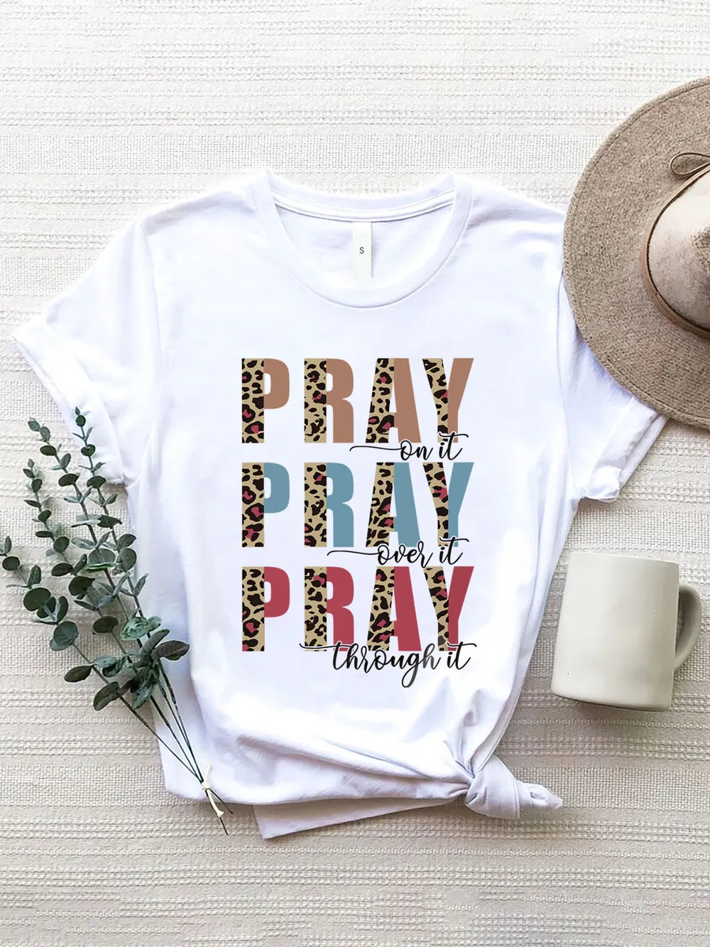 White short-sleeve tee with “Pray On It, Pray Over It, Pray Through It.” Classic fit, easy layer for denim, jackets, vests, and everyday faith style.