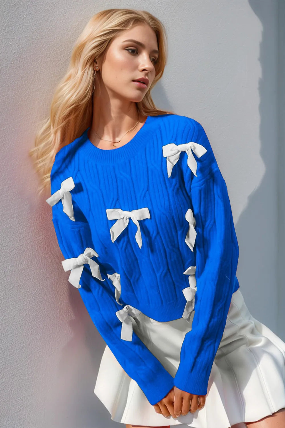 Women’s blue knit sweater with white stitched bows, long sleeves, soft casual-retro layering top for everyday cozy outfits.