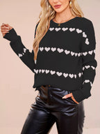Black long sleeve knit sweater with 4 rows of white hearts. Relaxed dropped shoulder fit, soft, opaque, everyday pullover style.