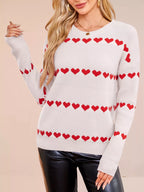 Ivory long sleeve knit sweater with 4 rows of red hearts and a relaxed dropped shoulder fit. Soft, opaque, everyday pullover style.