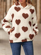 Fuzzy sherpa hoodie in off-white with brown heart-shaped pockets. Long sleeves, dropped shoulder pullover fit, soft cozy casual look.