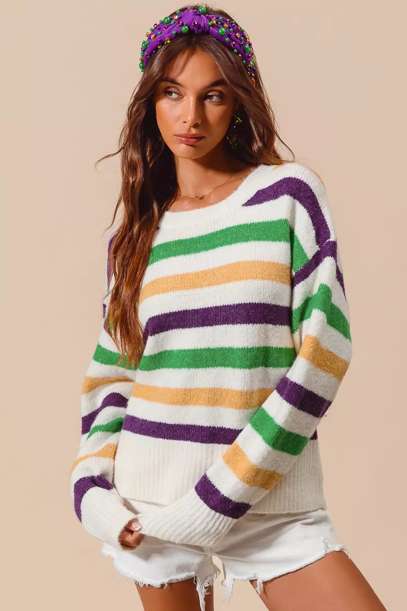 Ivory SO ME sweater top with vibrant purple, gold, and green stripes, round neckline, soft stretch knit fabric, long sleeves, relaxed fit, Mardi Gras parade-style sweater