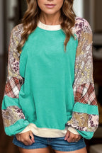 Teal raglan long sleeve top with printed patchwork sweater-style design. Western-boutique layering staple with a soft, slightly stretchy casual fit.