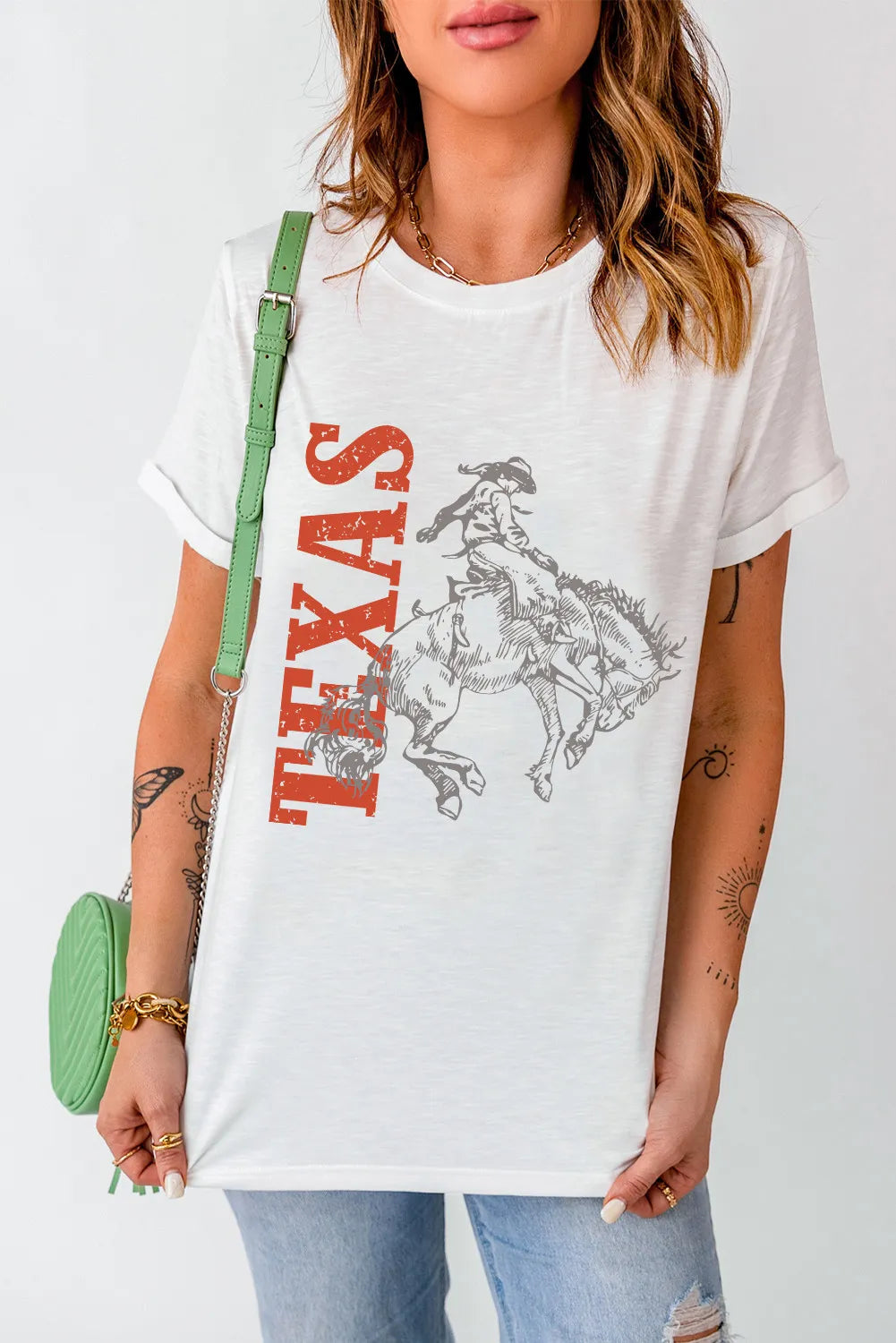 White graphic tee with bold orange “Texas” and a gray-outlined bucking bronc design. Easy to style with denim, vests, boots, and everyday western fits.
