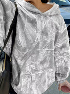 Light gray oversized hoodie with woodland camo print and full pockets. Opaque sweatshirt feel, casual outdoor style, relaxed fit, everyday-ready layer.