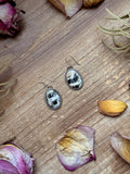 White Buffalo sterling silver dangle earrings handmade by Jason Ogg with bold black and white natural stone.